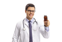 Amgen trippelfälls efter hyllande läkare i reklam Läkare håller piller läkemedelsreklam VP1 Reklam Istock