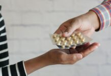 Var sjätte svensk tar andras receptläkemedel En person ger medicin till en annan person i randig tröja