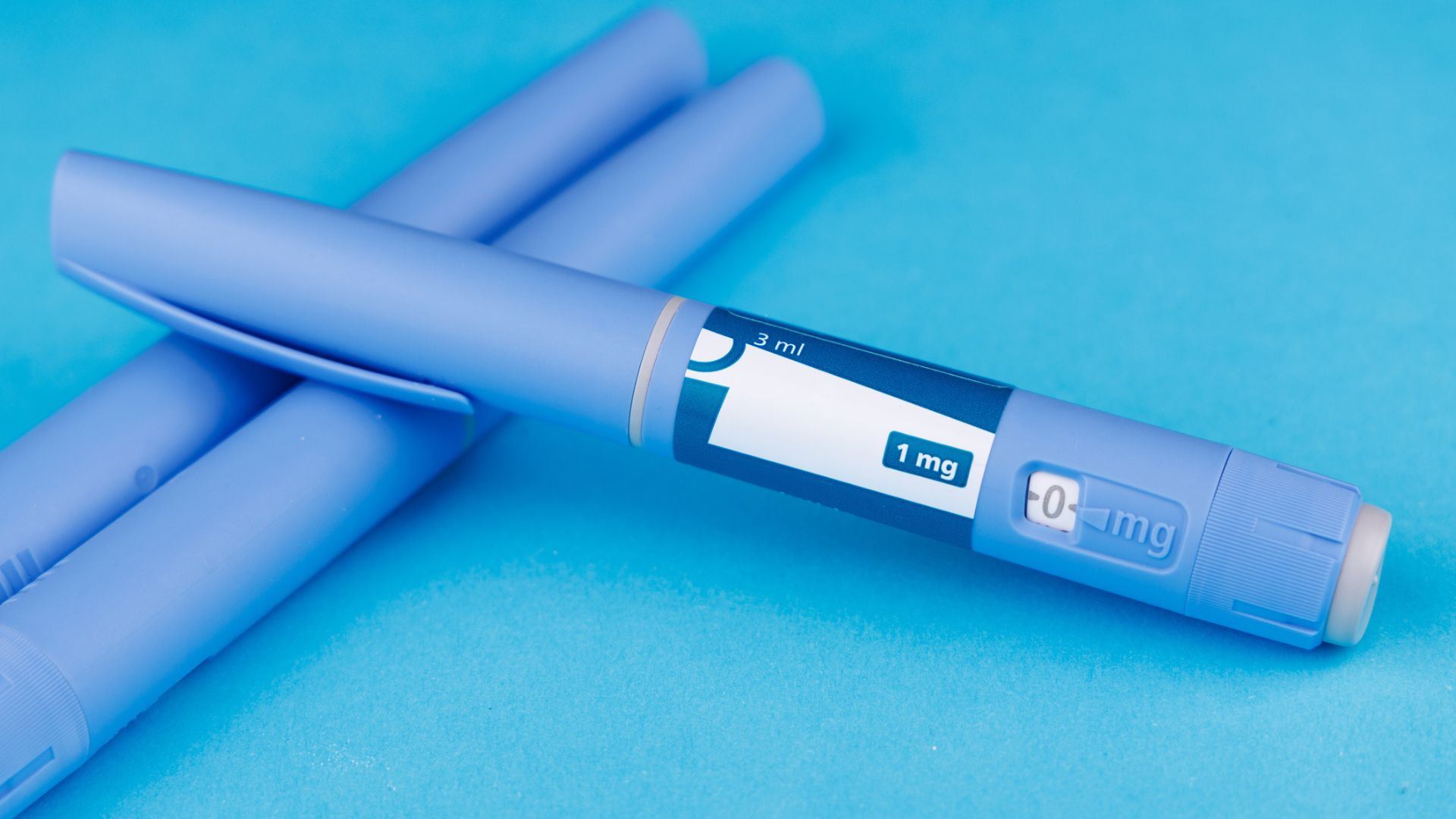 GLP-1-läkemedel i pennform, mot blå bakgrund