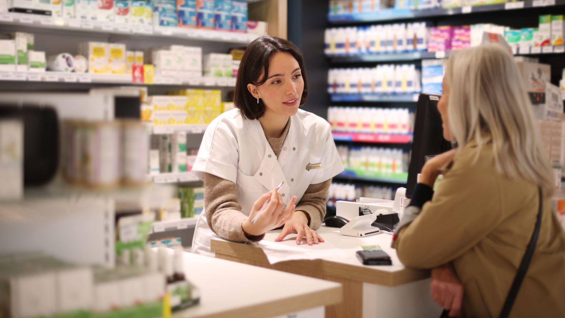 Farmaceut som ger råd till kund kring receptfria läkemedel
