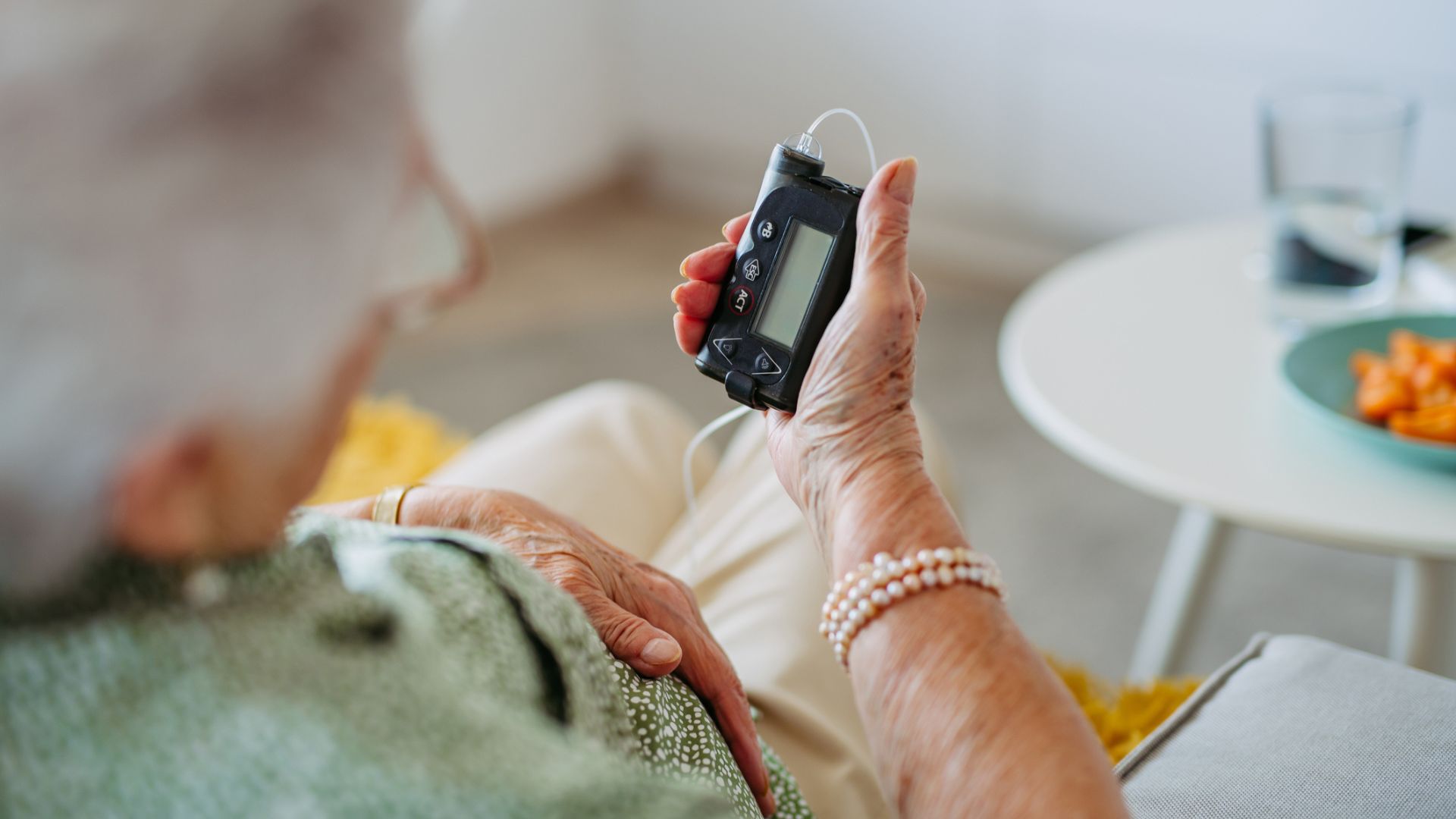 Äldre kvinna med diabetes typ 1 läser av sin insulinpump